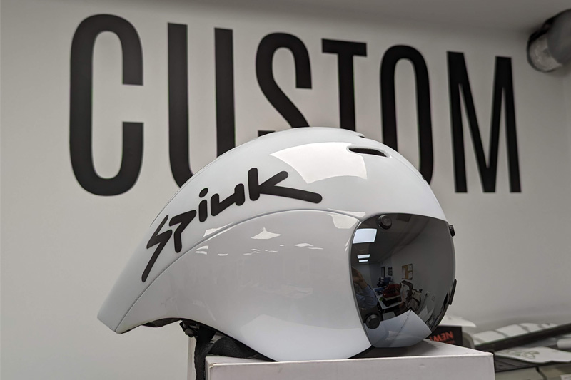 A white personalised bike helmet with black text sticker