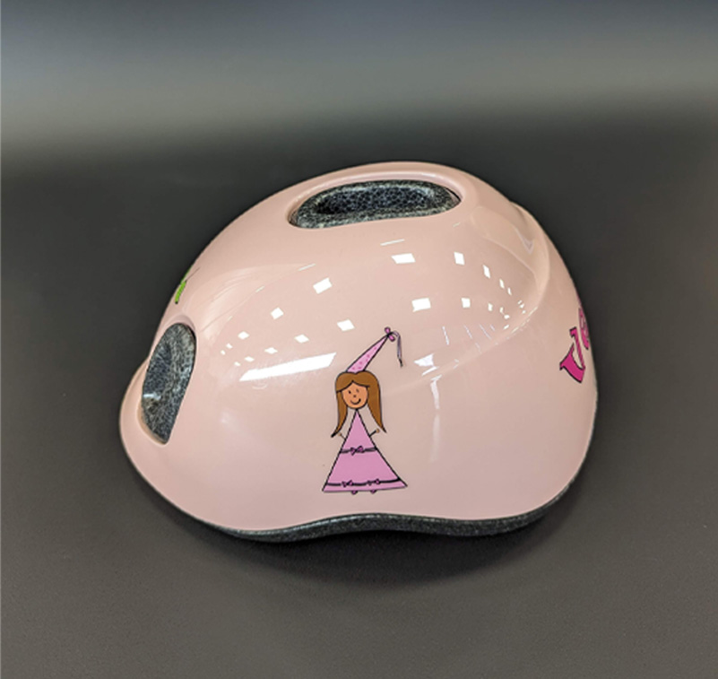 A child's pink helmet with a princess on it