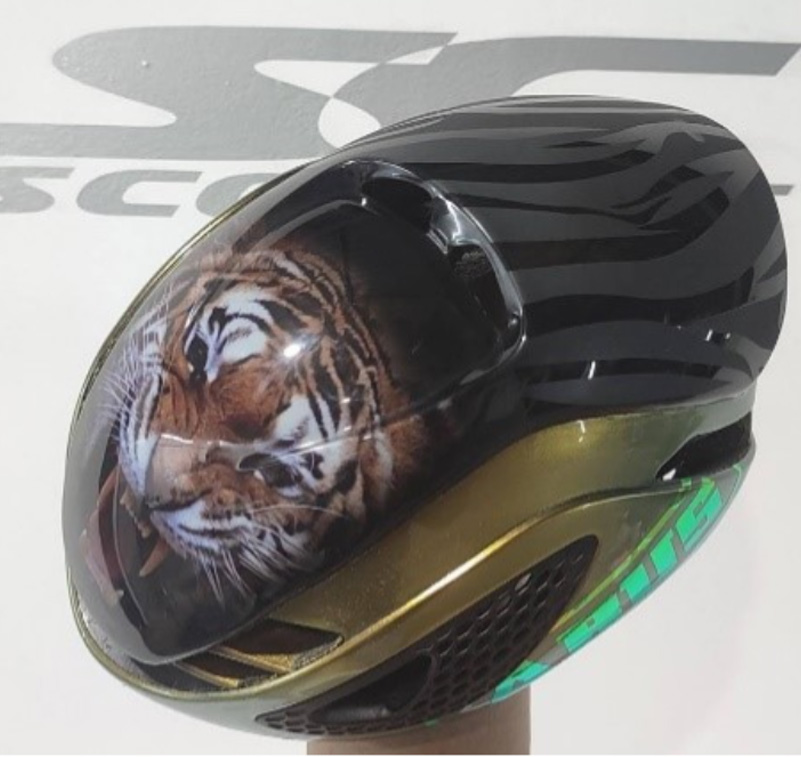 A black and gold bike helmet with a tiger design on it