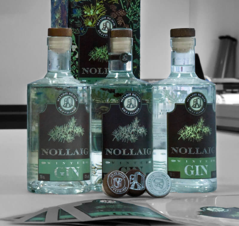 Tre bottiglie di gin con diversi esempi di etichette stampate