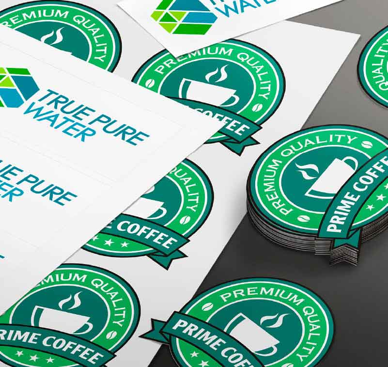 sheets of printed stickers with company logos and a stacks of stickers cut out