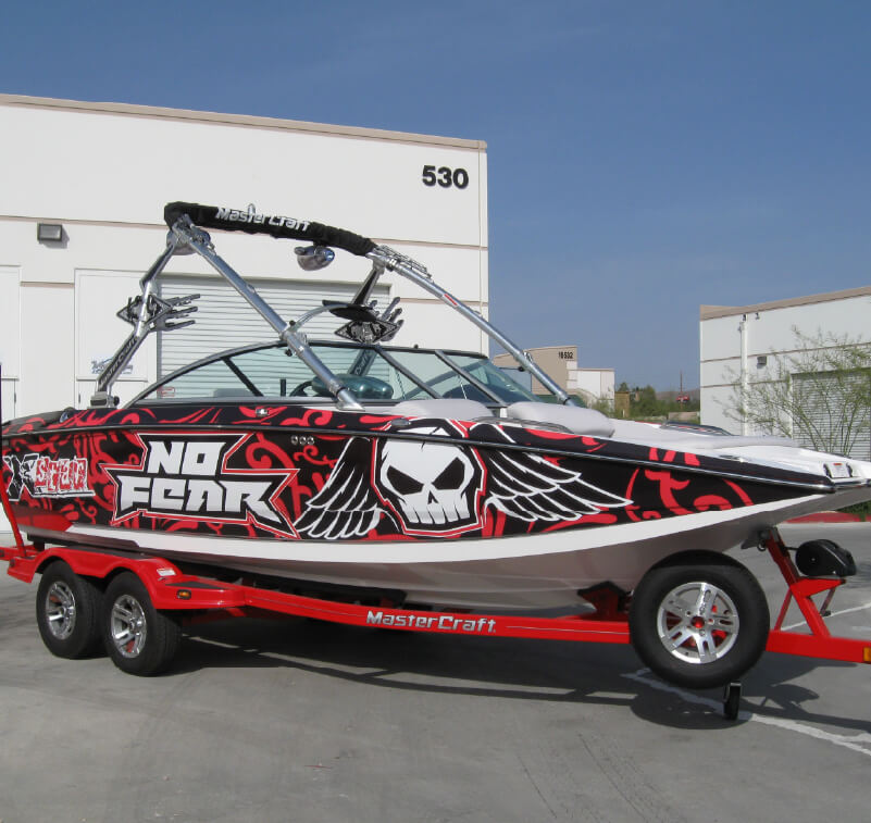 A boat with printed graphics on a trailer