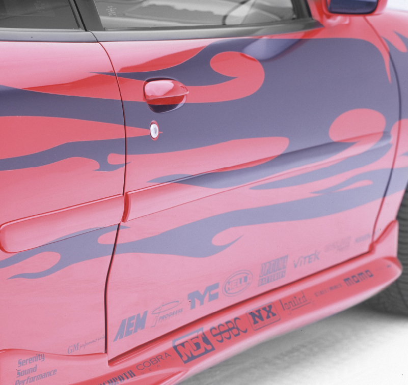 Primo piano della grafica di una fiamma nera e di un testo su un'automobile rossa