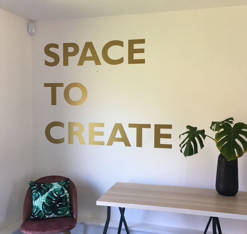 Eine Wand mit dem Schriftzug „Space to Create“ aus selbstklebender, geschnittener Vinylfolie