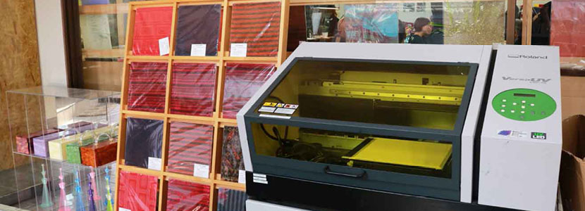 A Roland VersaUV LEF-12 UV printer is set up in the Miyuki Acryl studio