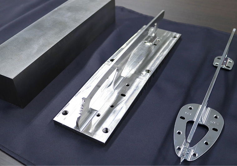 Un bloque de acero de más de 10 kg (izquierda) se fresa para fabricar la cuchilla final (derecha) con un peso de solo 270 g