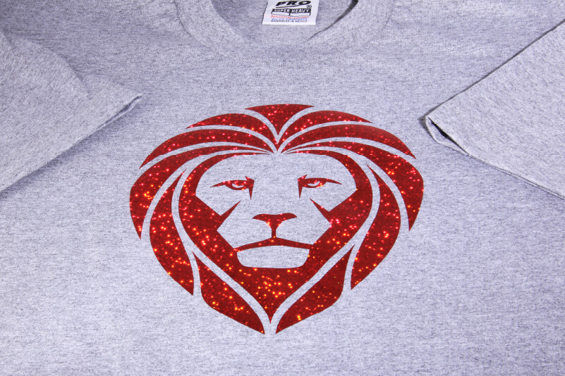 Grafik eines Löwen, der aus Glitzer-Vinylfolie geschnitten und mit Wärmepresse auf ein T-Shirt aufgebracht wurde