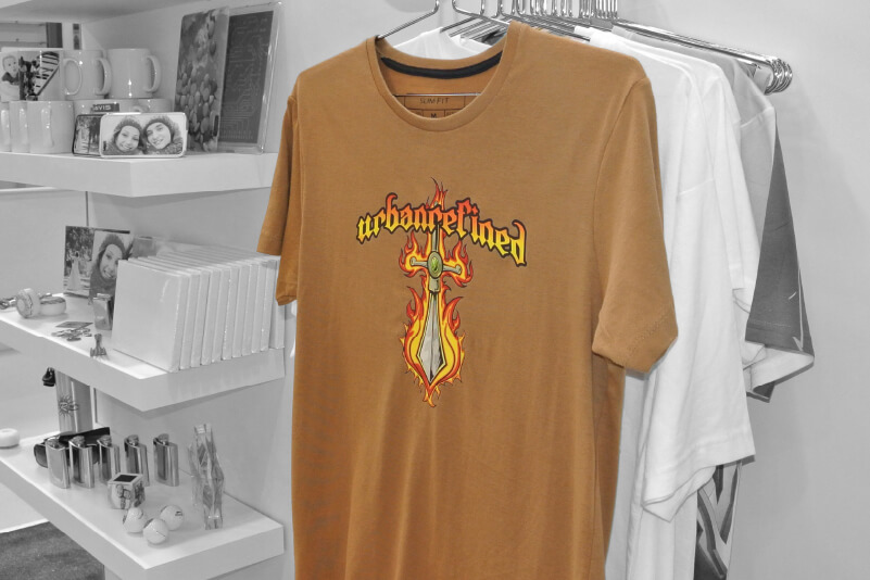A rack of t-shirts with a printed HTV design