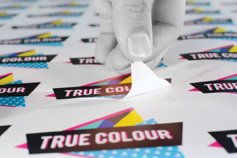 a sticker being peeled from a sheet of stickers