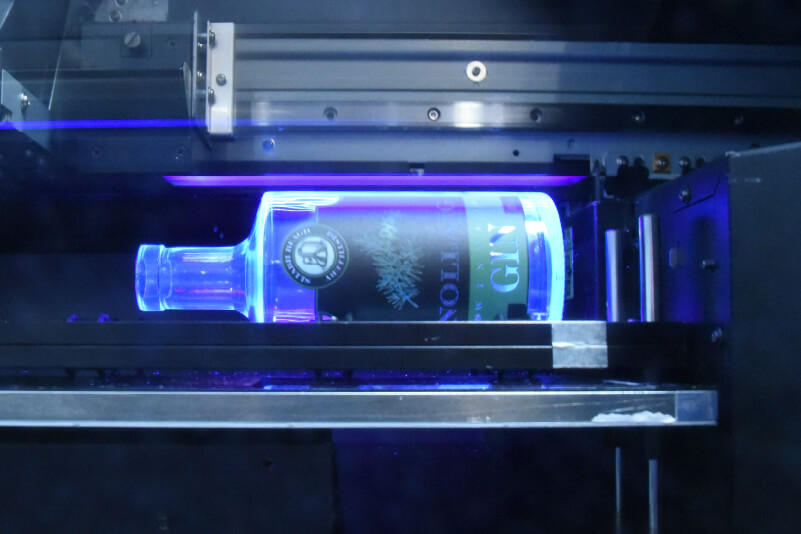 Rotary printing a glass bottle