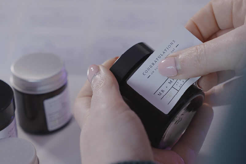 Applying a personalised sticker to a candle jar