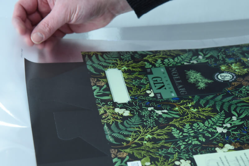 Carefully applying adhesive vinyl onto card