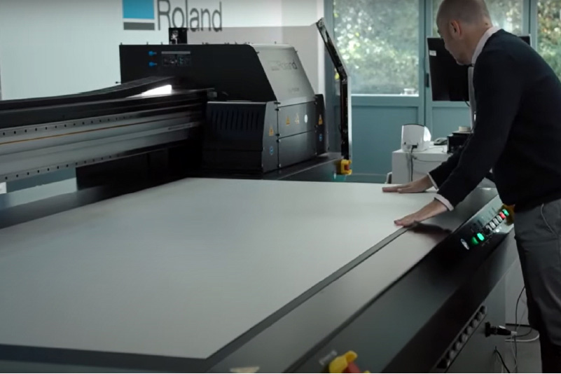 A person standing next to a large printer