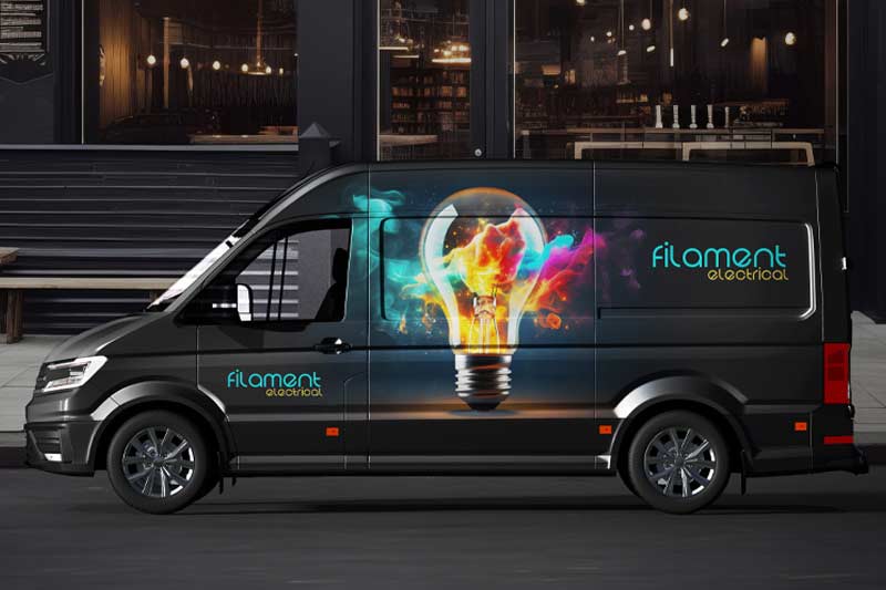 Un furgone nero con una grafica rappresentante una lampadina luminosa sul lato, che mostra una stampa accurata su pannello