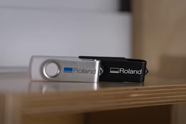A close-up of a USB stick with the Roland DG logo