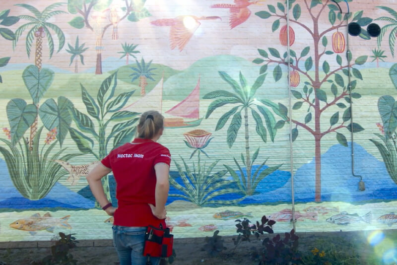 Una persona de pie delante de un mural (fuente: Avery Dennison)