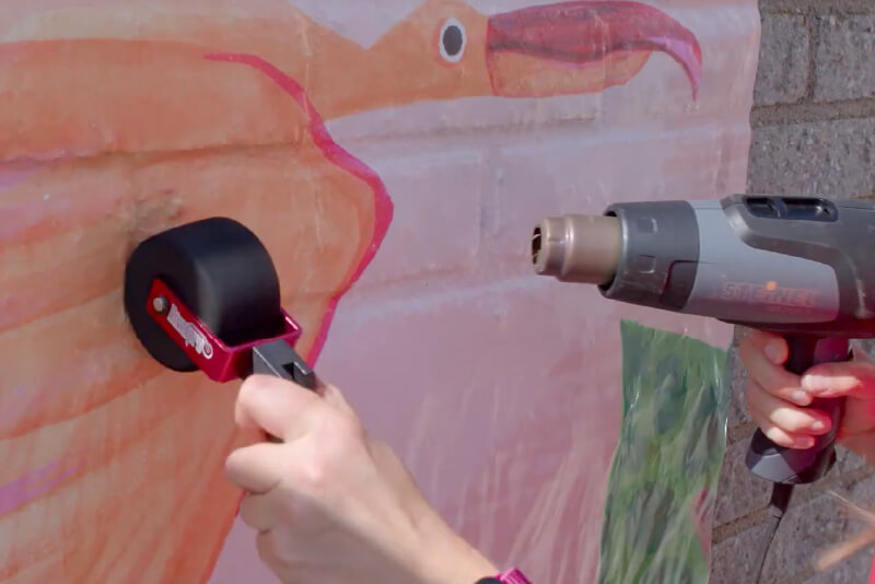 Using a heat gun and roller to apply graphics on an exterior wall (Source: Avery Dennison)