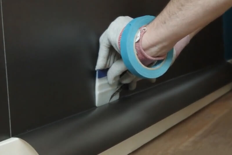 Using a knife and squeegee to maintain a straight edge when trimming vinyl (Source: Avery Dennison)
