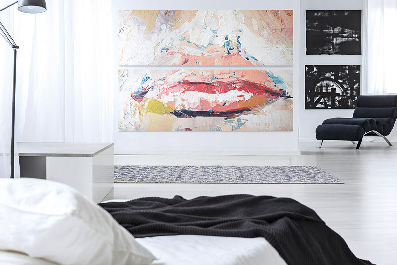 A bedroom with a large artistic print on the wall