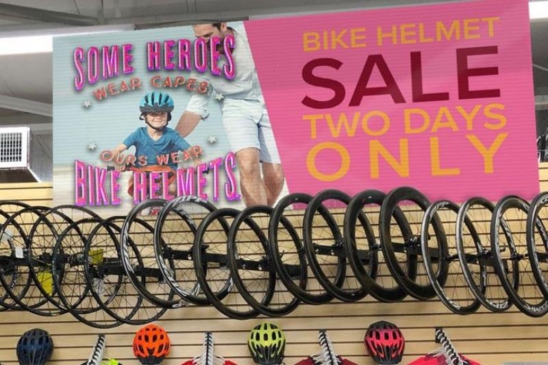 bannière de vente promotionnelle de casques de vélo pour deux jours seulement accrochée dans un magasin de vélos