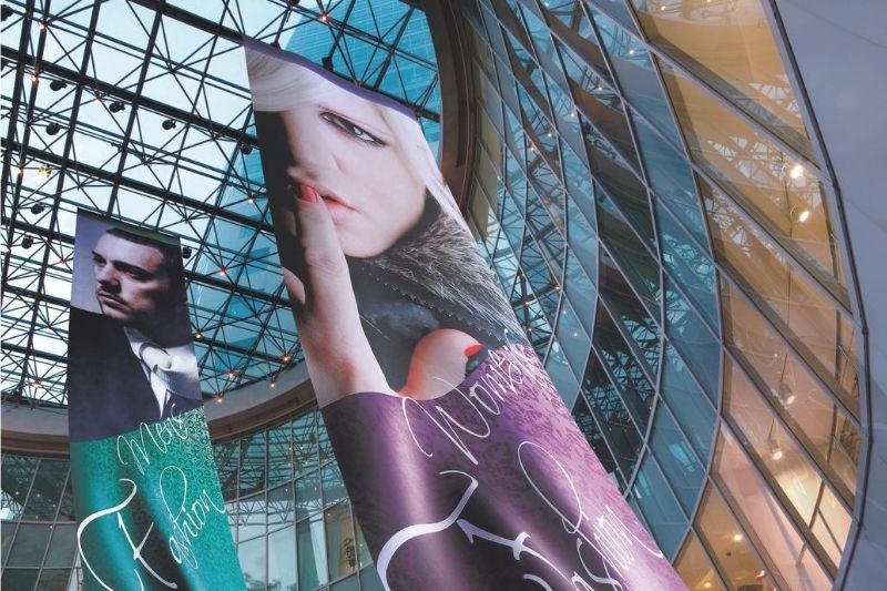 Hängendes Transparent mit Thermosublimationsdruck in Einkaufszentrum als Werbung für ein Bekleidungsgeschäft