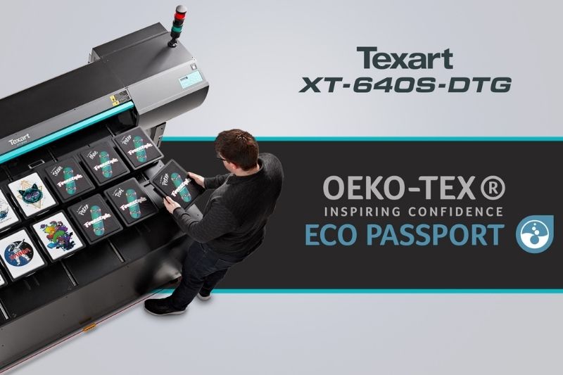 Texart XT-640S-DTG yazıcısı tarafından tasarlanmış tişörtlerin yanında duran kişi. ECO PASSPORT by OEKO-TEX onaylı logosu