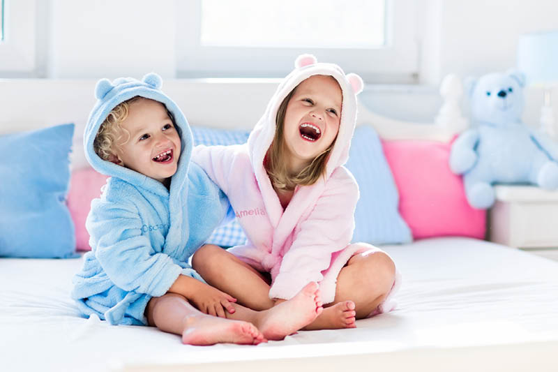two children wearing personalised bath robes 