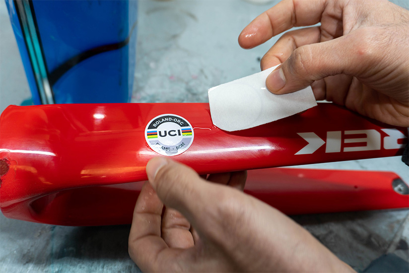 Sergio sliding the decals off the paper and apply them to the bike frame