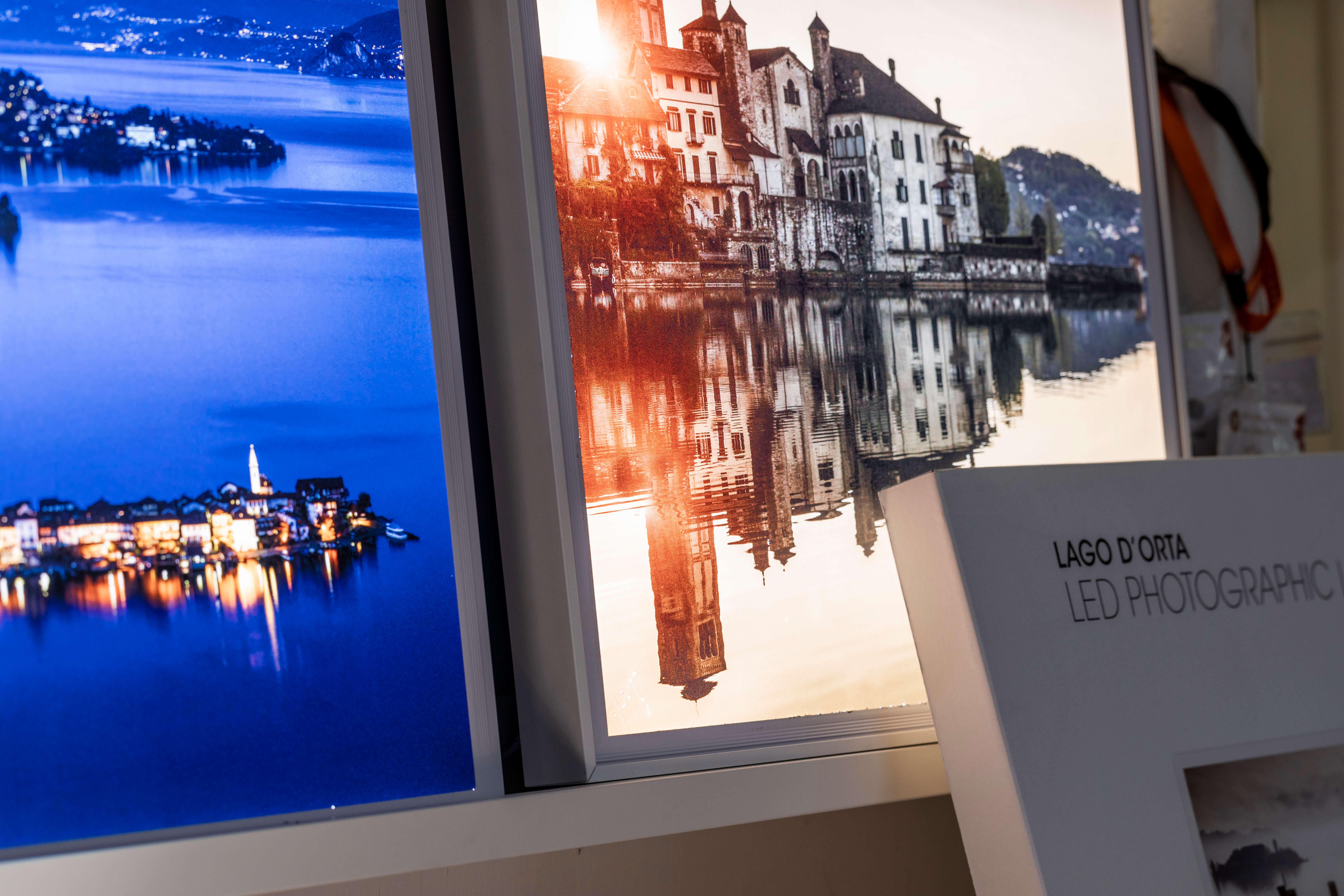 Mit der Roland VersaUV LEC2 S Reihe hergestellte hintergrundbeleuchtete Drucke von Fotos, die den Ortasee und den Lago Maggiore zeigen.