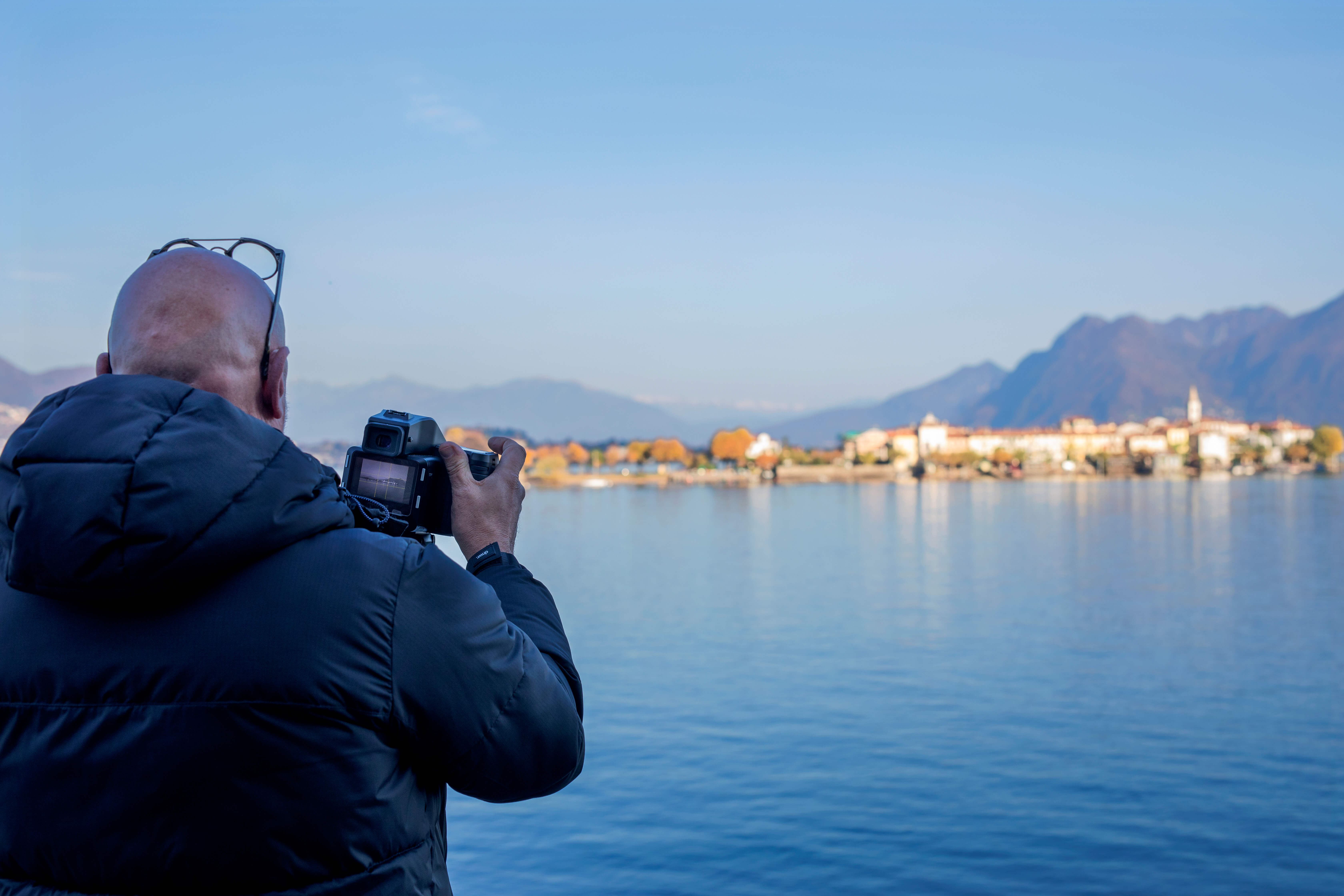 Der Fotograf vor dem Lago Magiore beim Fotografieren einer Momentaufnahme seiner Region.