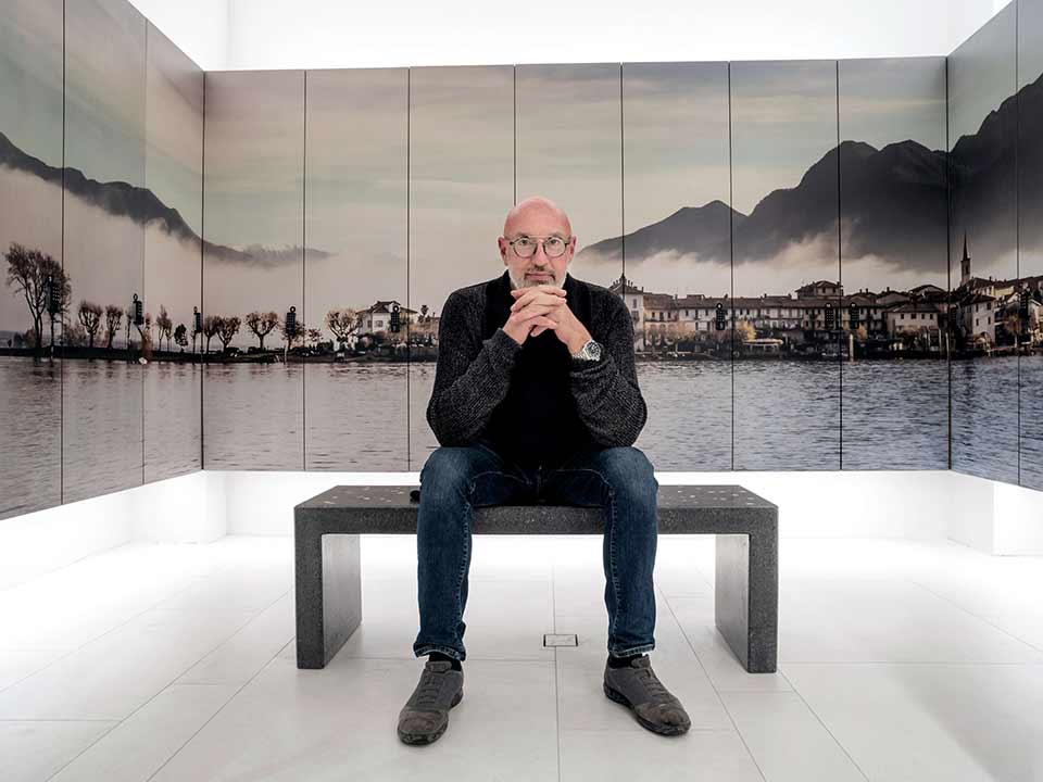 The photographer Walter Zerla, surrounded by his photo panels made with Roland LEC2 S flatbed UV printer for an exclusive spa in Stresa on Lake Maggiore.