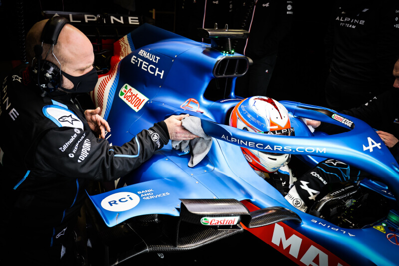 Technicien appliquant un covering sur une voiture F1 